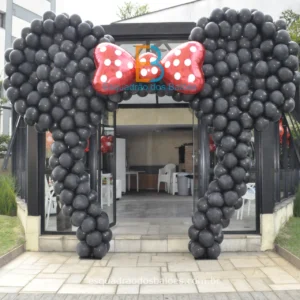 um arco de balões pretos com laço vermelho que formam a cabeça da Minnie Mouse.