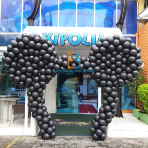 um arco de balões pretos que formam a cabeça do Mickey Mouse.