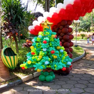 A imagem trata-se de uma arvore de natal confeccionada em balões em tons de verde.
